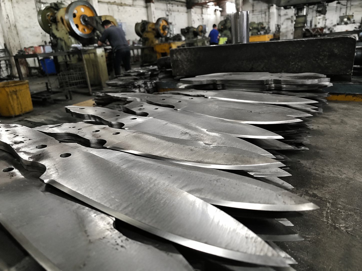 Stacks of knife blade blanks in a working factory environment