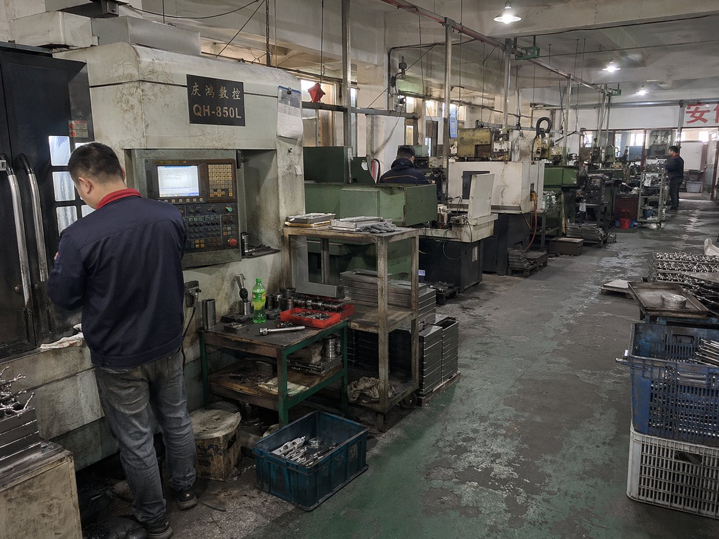 CNC machinery and operators inside a knife factory workshop