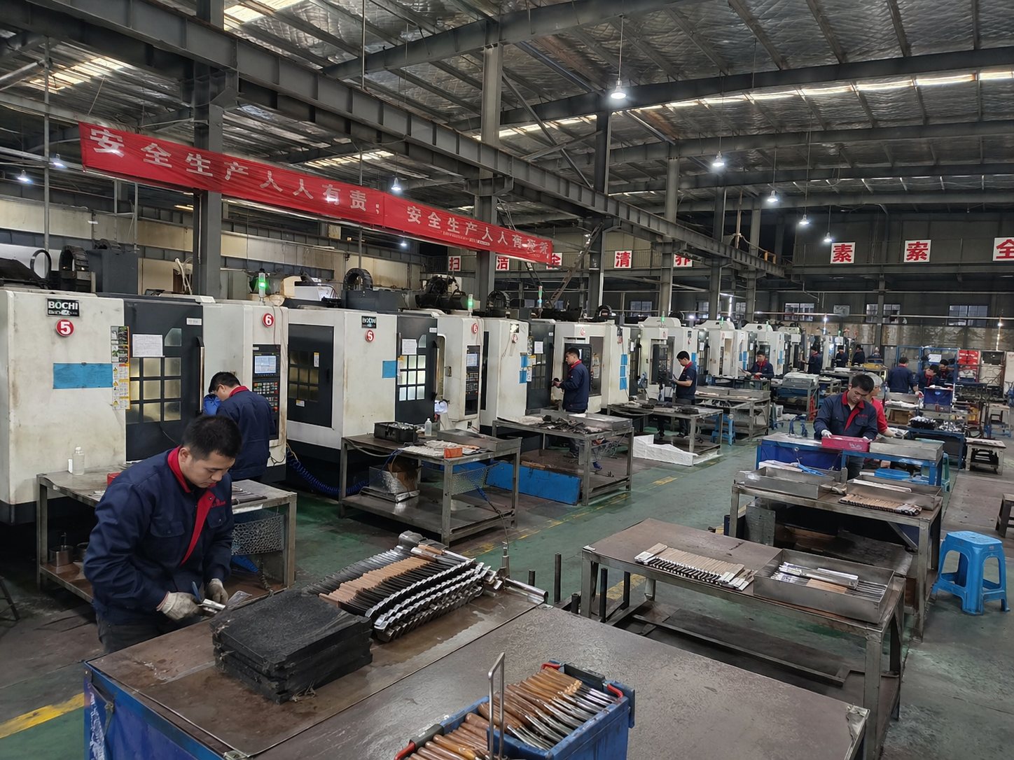 Knife factory floor with CNC machines and workers supporting B2B production follow-up